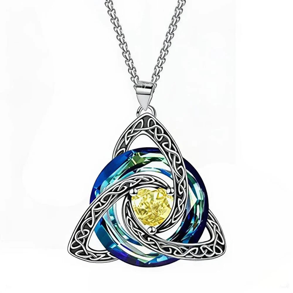 A silver Celtic triquetra knot pendant necklace featuring a central yellow crystal surrounded by layered blue and green swirled glass rings, suspended from a silver chain on a white background.