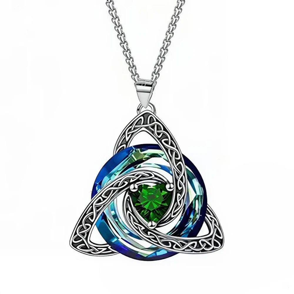 A silver Celtic triquetra knot pendant necklace featuring a swirling blue and green crystal design, shown on a white background.