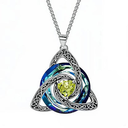 A silver Celtic triquetra knot pendant necklace featuring a central round blue iridescent gemstone and a faceted light green center stone, suspended from a silver chain on a white background.