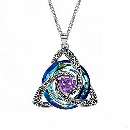 A silver Celtic knot triquetra pendant necklace featuring a central purple heart-shaped crystal surrounded by layered blue and green iridescent swirls, suspended from a silver chain on a white background.