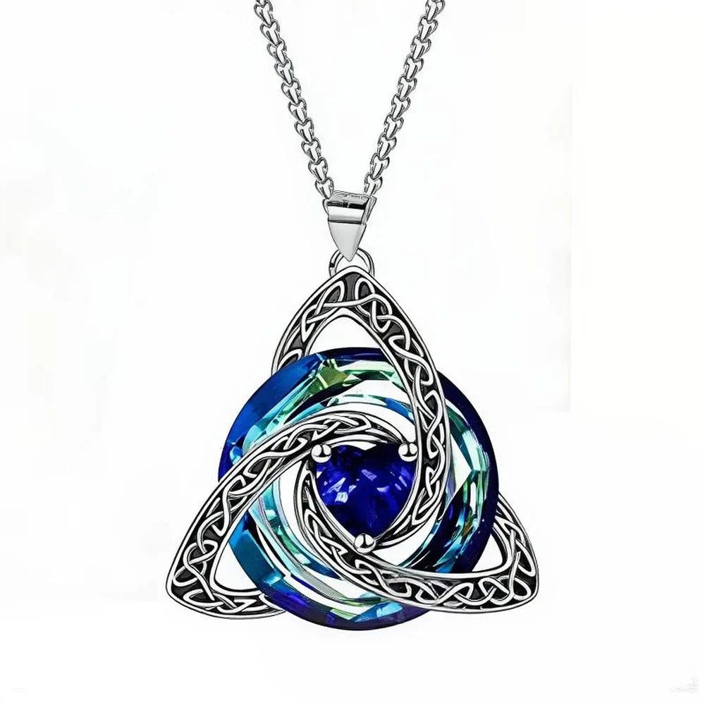 A silver Celtic knot triquetra pendant necklace featuring a swirling blue and green faceted crystal design, shown on a white background.