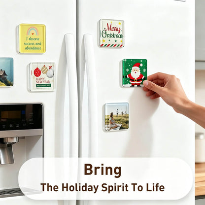 A hand is attaching a square holiday magnet to a white refrigerator door, with other decorative fridge magnets visible around it. The scene includes a text overlay that reads 'Bring The Holiday Spirit To Life.