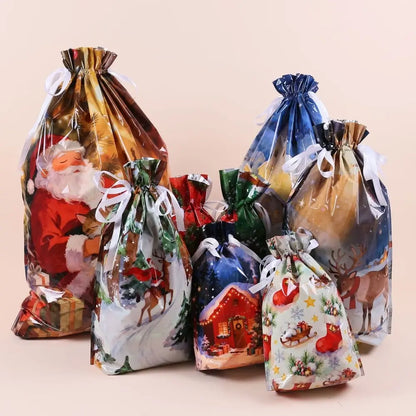 A set of Christmas-themed drawstring gift bags with various festive prints including Santa Claus, reindeer, a snowy house, and a sleigh, arranged together on a solid light beige background.