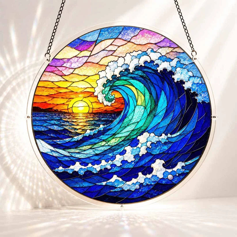 A round acrylic suncatcher showing a giant blue ocean wave at sunset with a glowing sun and coastal sky