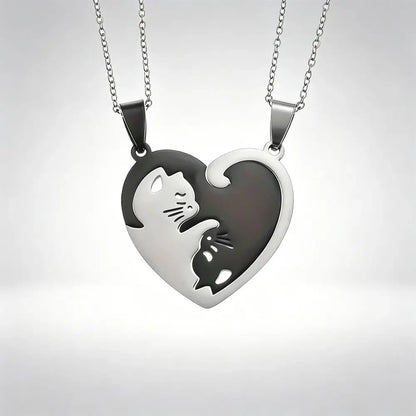 Two matching silver heart-shaped pendant necklaces with cat cutouts, displayed against a light gray gradient background.