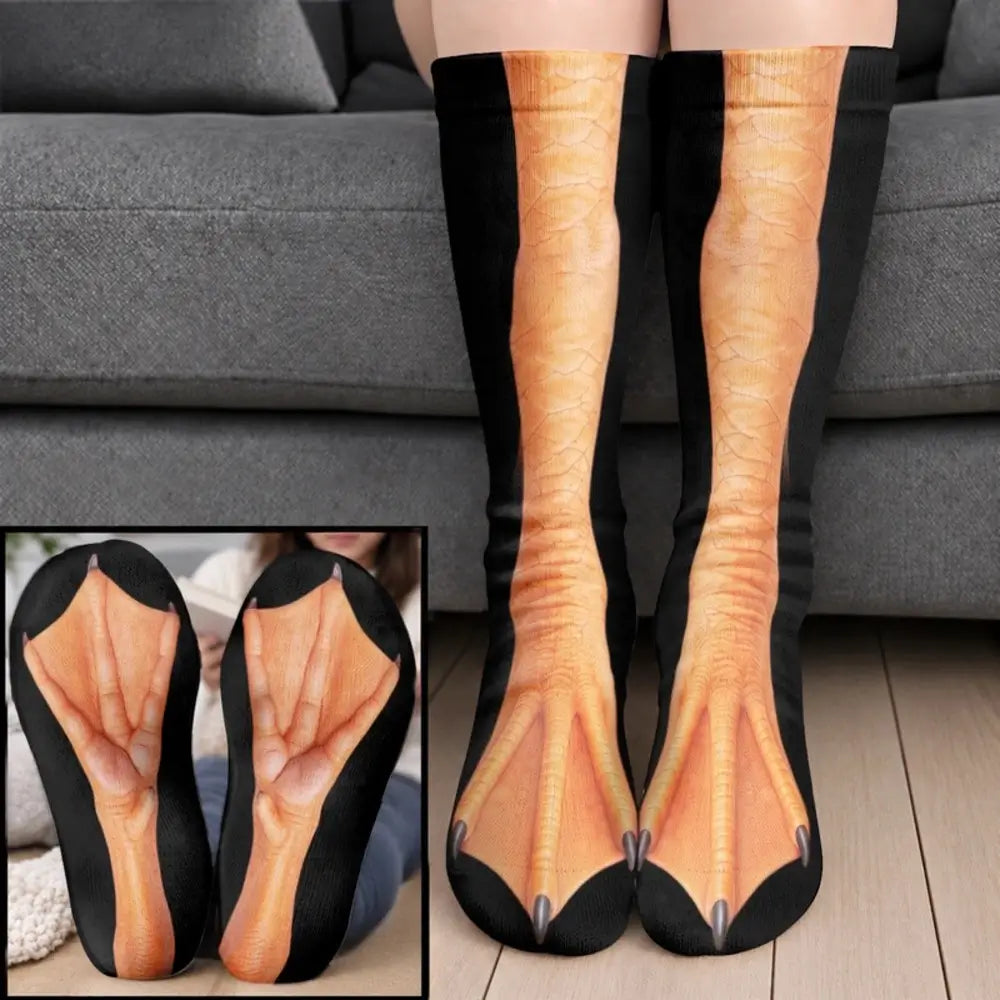 Orange duck webbed foot socks with black side panels worn on legs before a gray sofa