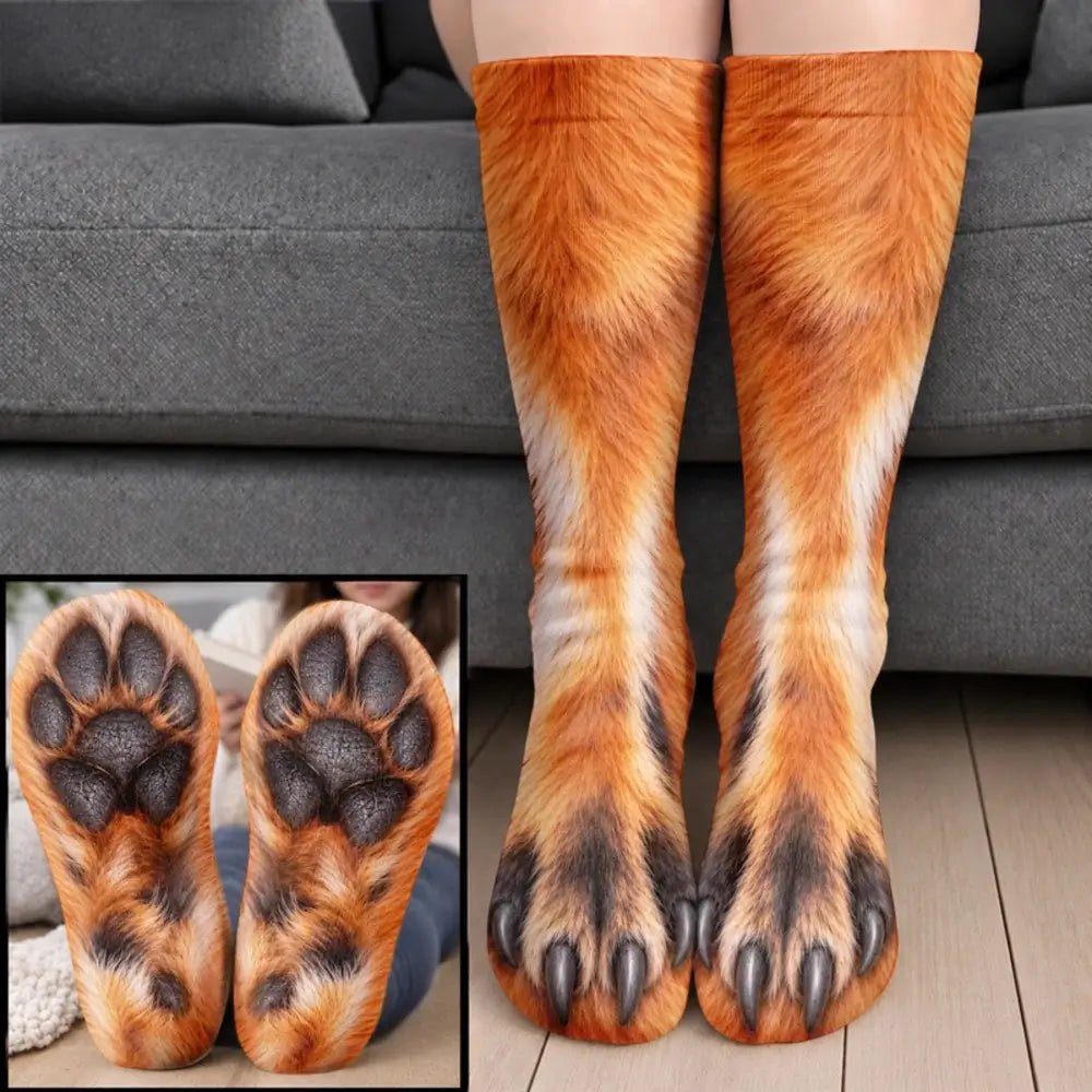 Orange fox fur claw socks with dark paw pads worn on legs before a gray sofa