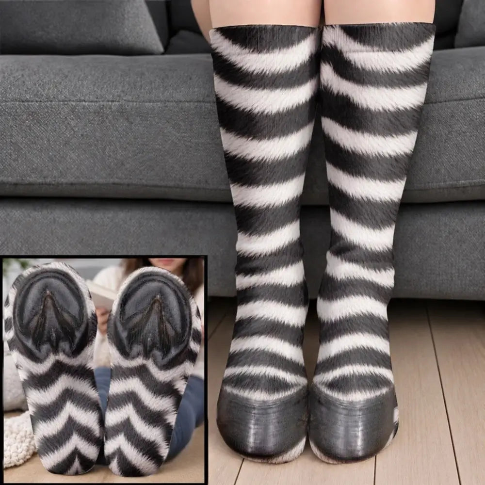 Black and white striped zebra leg socks with black hoof toes worn on legs before a gray sofa