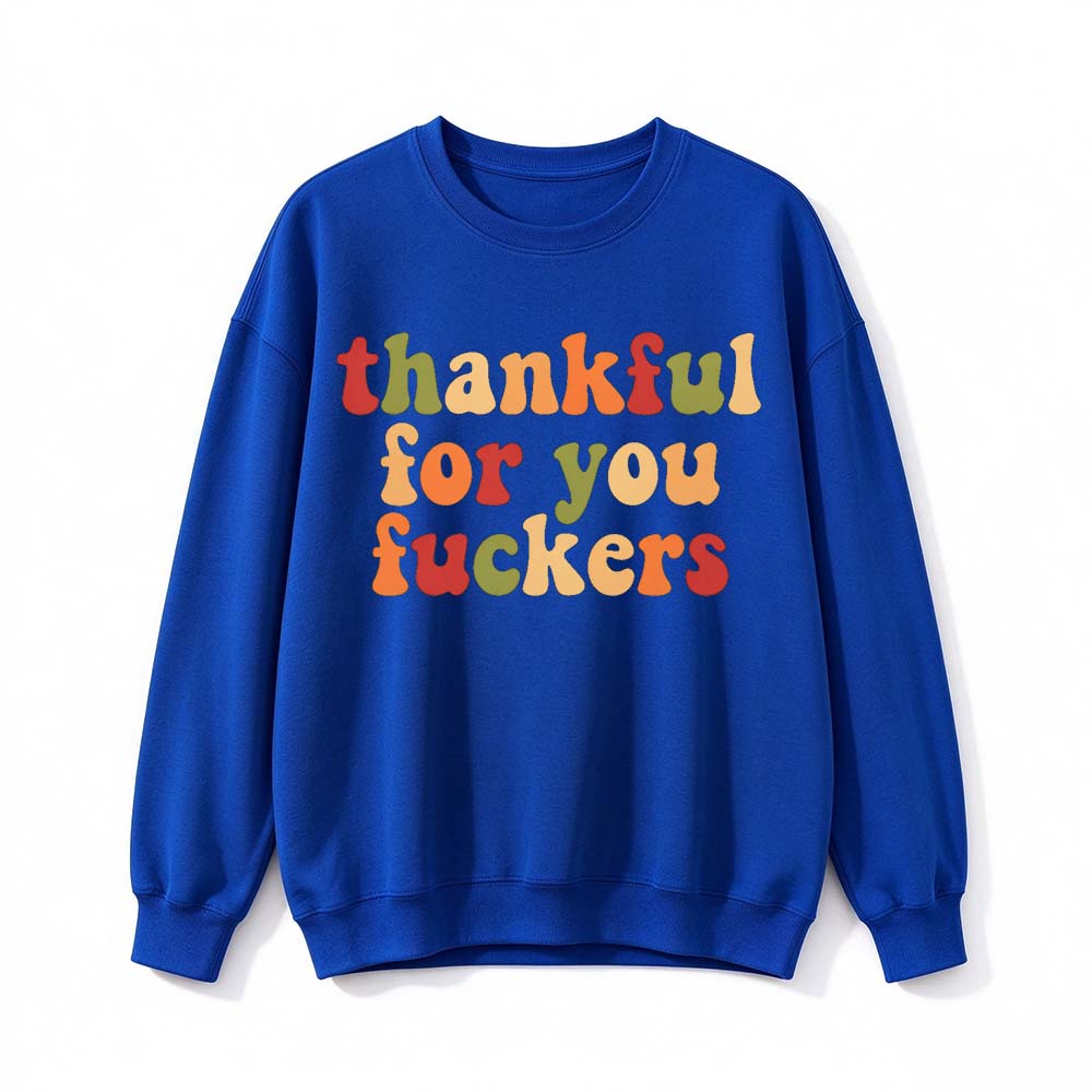 A royal blue crew neck sweatshirt printed with three lines of retro multicolor Thanksgiving lettering on a white background