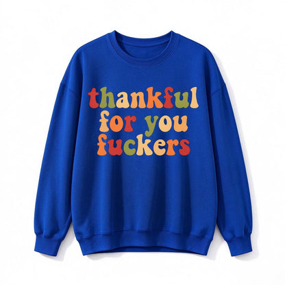 A royal blue crew neck sweatshirt printed with three lines of retro multicolor Thanksgiving lettering on a white background