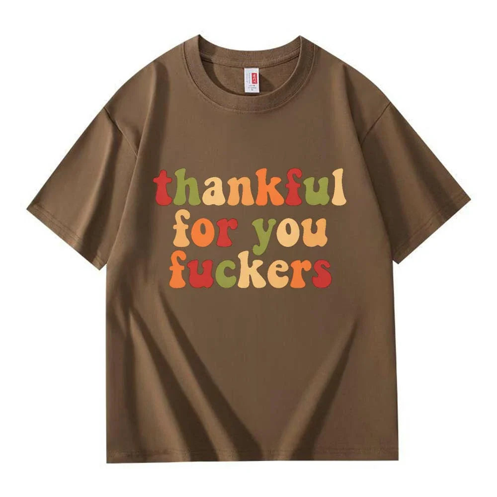 A dark brown crew neck T-shirt with three lines of retro multicolor Thanksgiving lettering on a white background