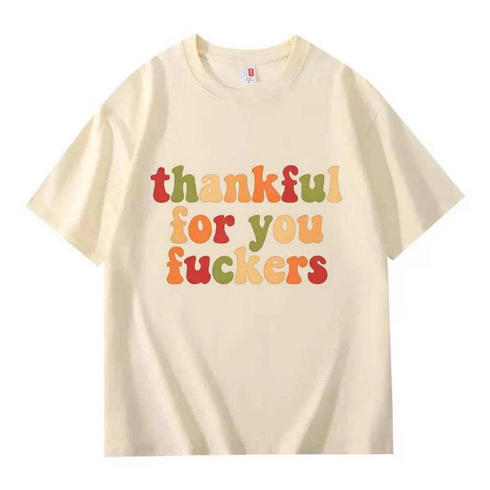 A cream crew neck T-shirt with three lines of retro multicolor Thanksgiving lettering on a white background