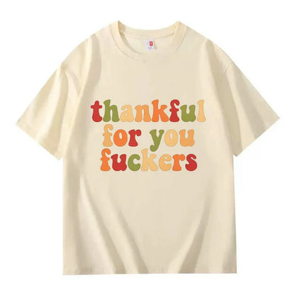 A cream crew neck T-shirt with three lines of retro multicolor Thanksgiving lettering on a white background