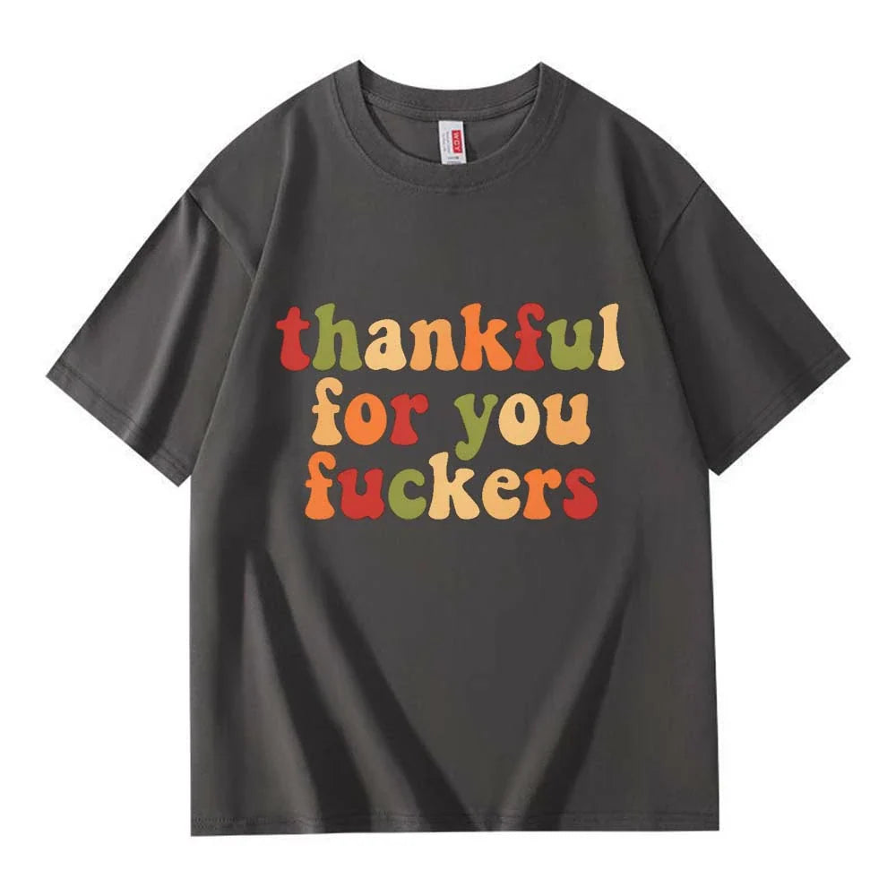 A dark gray crew neck T-shirt with three lines of retro multicolor Thanksgiving lettering on a white background