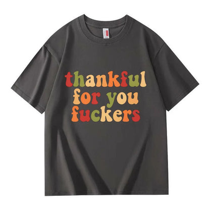 A dark gray crew neck T-shirt with three lines of retro multicolor Thanksgiving lettering on a white background