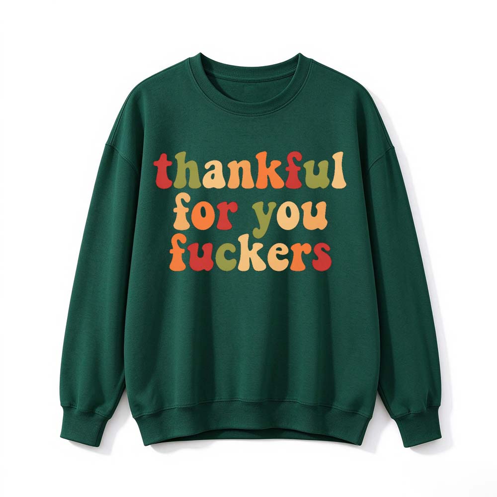 A dark green crew neck sweatshirt printed with three lines of warm colored retro Thanksgiving lettering on a white background
