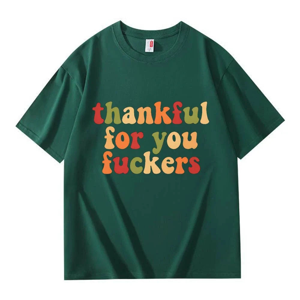 A dark green crew neck T-shirt with three lines of retro multicolor Thanksgiving lettering on a white background