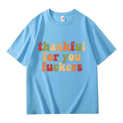 A light blue crew neck T-shirt with three lines of retro multicolor Thanksgiving lettering on a white background