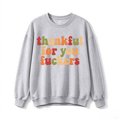 A light gray crew neck sweatshirt printed with three lines of multicolor gradient Thanksgiving lettering on a white background