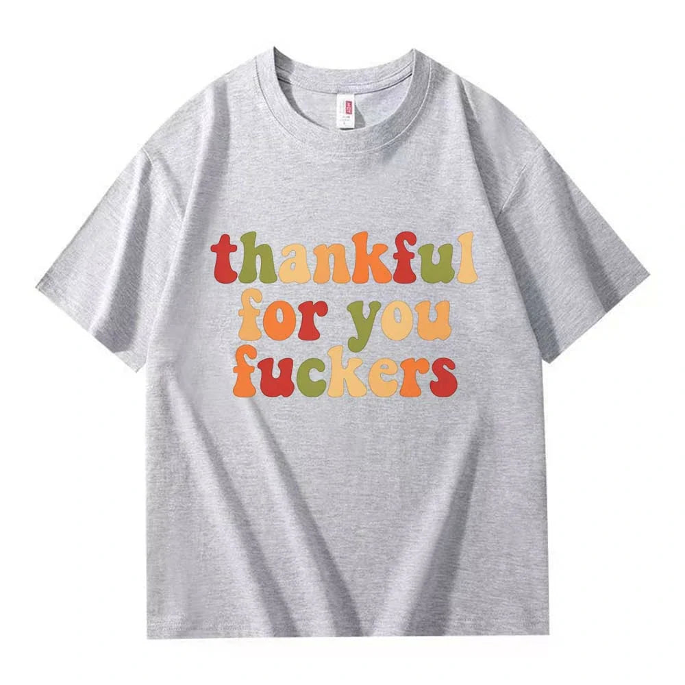 A light gray crew neck T-shirt with three lines of retro multicolor Thanksgiving lettering on a white background