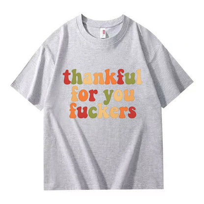 A light gray crew neck T-shirt with three lines of retro multicolor Thanksgiving lettering on a white background