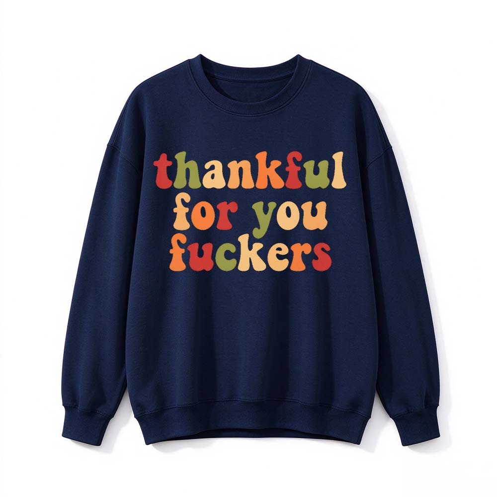 A navy blue crew neck sweatshirt printed with three lines of multicolor gradient Thanksgiving lettering on a white background