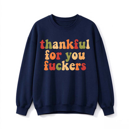A navy blue crew neck sweatshirt printed with three lines of multicolor gradient Thanksgiving lettering on a white background