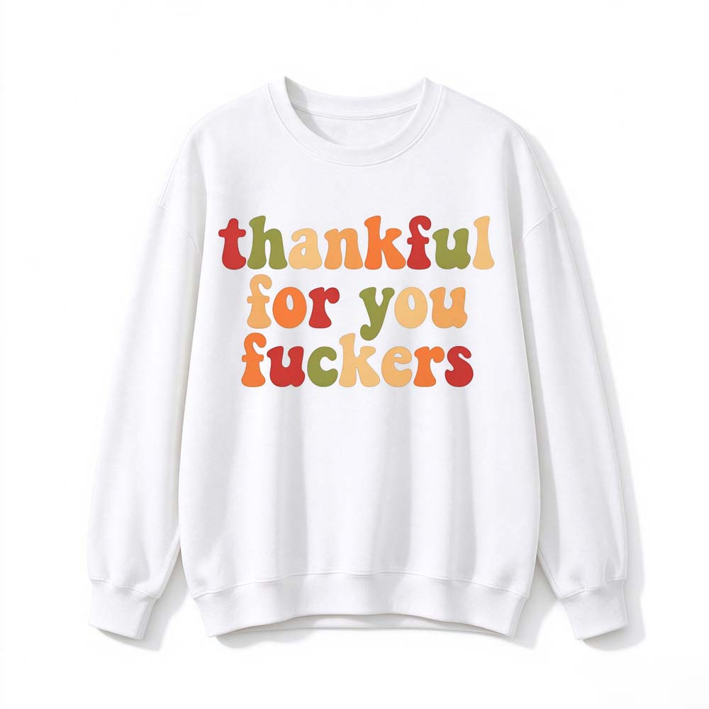 A white crew neck sweatshirt printed with three lines of retro multicolor Thanksgiving lettering on a white background