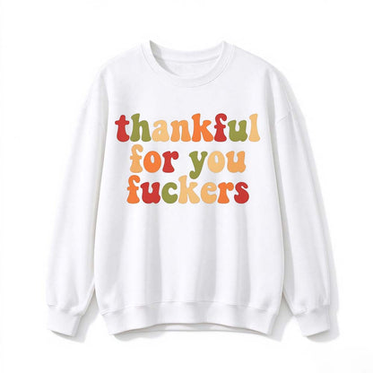 A white crew neck sweatshirt printed with three lines of retro multicolor Thanksgiving lettering on a white background