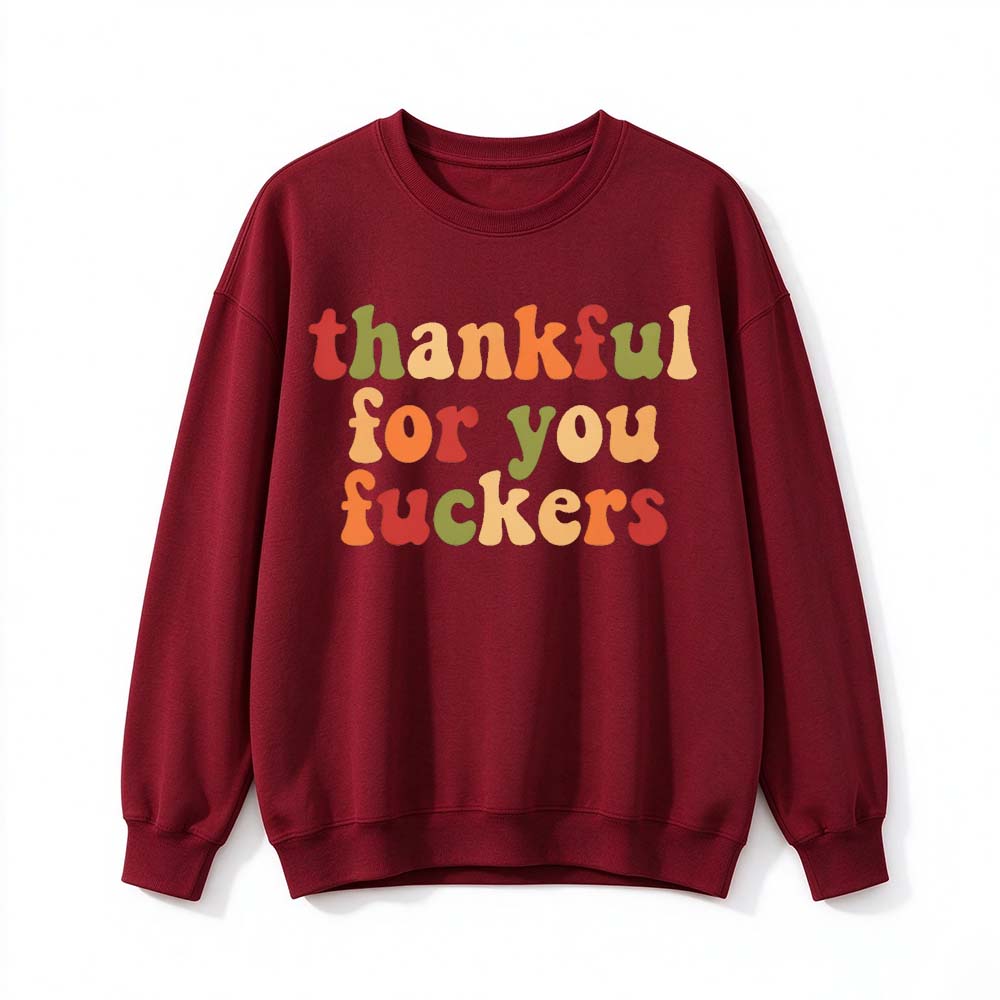 A wine red crew neck sweatshirt printed with three lines of retro multicolor Thanksgiving lettering on a white background