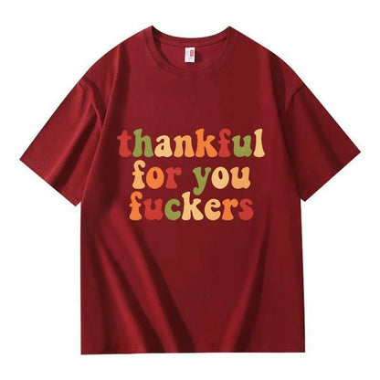 A wine red crew neck T-shirt with three lines of retro multicolor Thanksgiving lettering on a white background