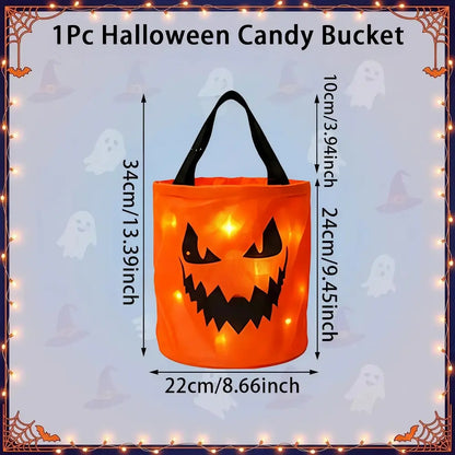 An orange pumpkin-shaped Halloween candy bucket with black handles and a jack-o'-lantern face, shown with dimension labels for height, width, and handle length on a light blue decorative background.