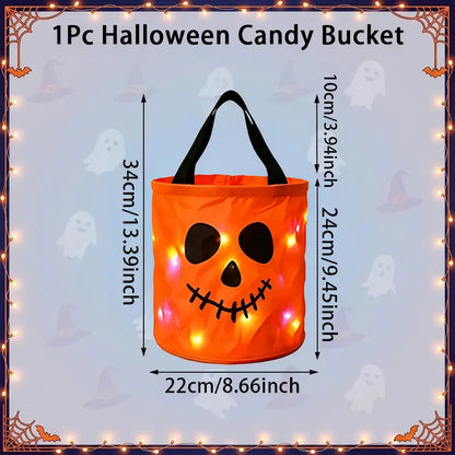 An orange pumpkin-shaped Halloween candy bucket with black handles and a stitched jack-o'-lantern face