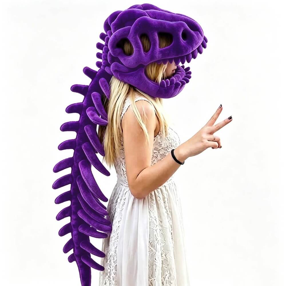 A woman wearing a plush purple dinosaur skull helmet with a long matching tail, posed against a plain white background.