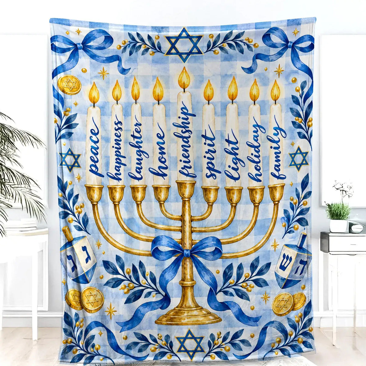 The Hanukkah blanket with a golden menorah and two dreidels hangs as a decorative wall piece against a white wall