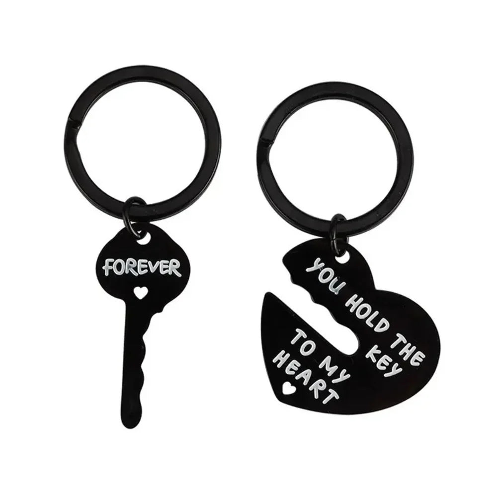 Black key and heart-shaped keychain with engraved text on a white background