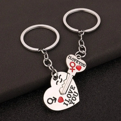 Two keychain pairs with heart and key designs on a dark background