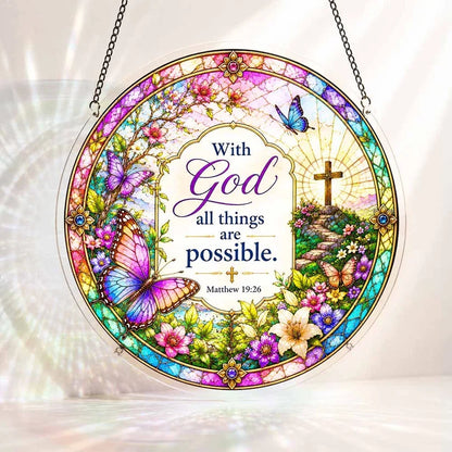 A round acrylic suncatcher decorated with butterflies flowers and a cross featuring the bible verse with God all things are possible