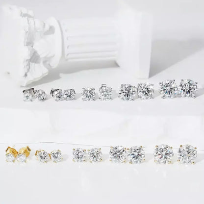 Pair of solitaire moissanite stud earrings displayed with jewelry