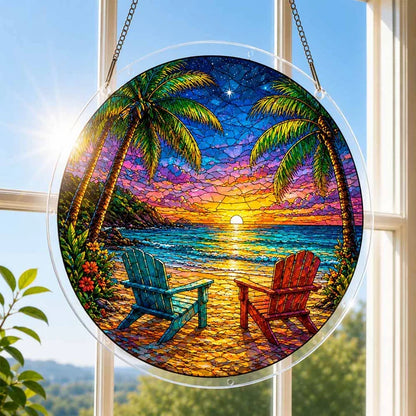A round acrylic suncatcher with a tropical beach sunset two adirondack chairs and palm trees hanging from a chain in front of a bright white window