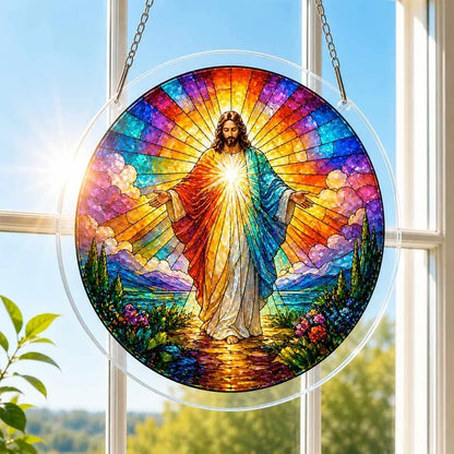 A round acrylic suncatcher depicting a radiant Jesus figure with open arms hanging from a chain in front of a bright white window