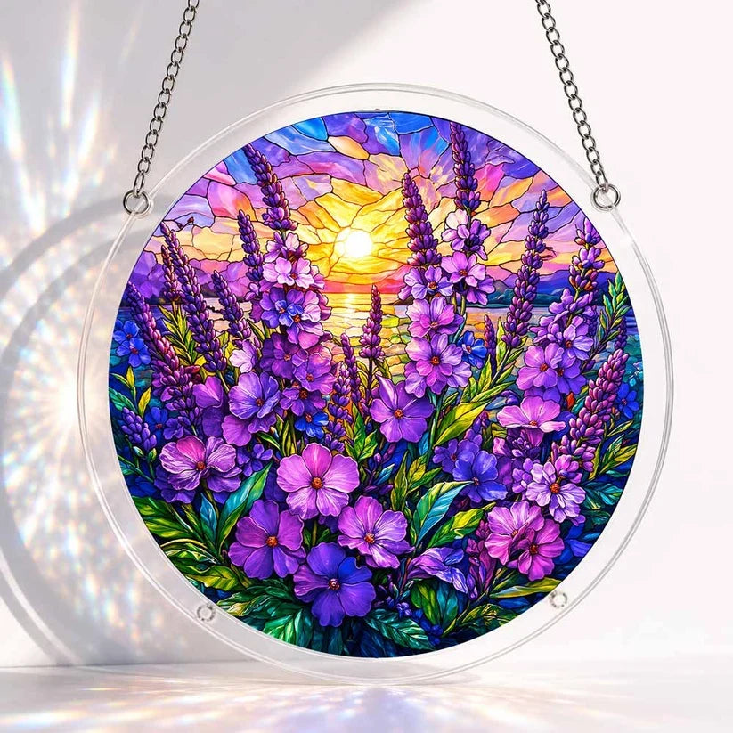 A round acrylic suncatcher filled with purple and violet wildflowers beneath a glowing sunset over the horizon