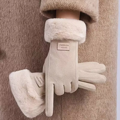 A pair of beige faux-suede winter gloves with fluffy cream faux-fur cuffs, shown on a model wearing a matching beige coat. 
