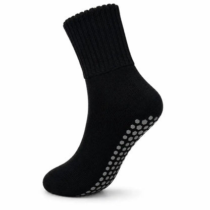 A single black ankle sock with gray non-slip grip dots on the sole, shown against a plain white background.